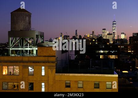 Vue au crépuscule sur les gratte-ciel de Lower Manhattan et One World Trade Center depuis le quartier de Meatpacking avec une tour d'eau au sommet d'un immeuble d'appartements en premier plan. Manhattan.New York City.USA Banque D'Images