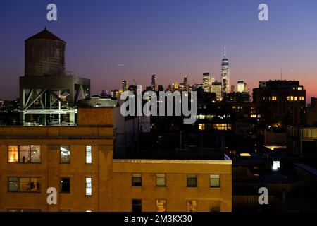 Vue au crépuscule sur les gratte-ciel de Lower Manhattan et One World Trade Center depuis le quartier de Meatpacking avec une tour d'eau au sommet d'un immeuble d'appartements en premier plan. Manhattan.New York City.USA Banque D'Images