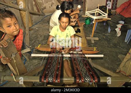 Wenty Fattu produisant les textiles tissés traditionnels de l'île de Rote lors de son atelier dans le village de Ndao, sur l'île de Rote, sur la régence de Rote Ndao, dans la province de Nusa Tenggara est, en Indonésie. Chaque mois, sa famille produit trois tissus dont le prix est compris entre 300 000 et 500 000 IDR. Banque D'Images