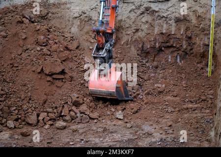 digger creusant un grand trou pour une piscine et mètre ruban pour tester la profondeur Banque D'Images