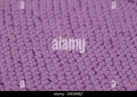 Toile de fond de texture macro abstraite défoquée d'un tissu de couleur rose lavande tricoté à la main avec un motif de couture en jarretière Banque D'Images