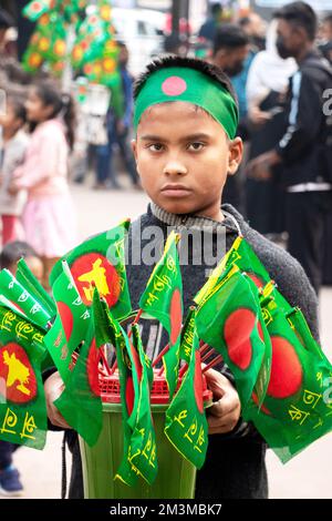 Narayanganj, Dhaka, Bangladesh. 16th décembre 2022. Un enfant présente des drapeaux nationaux du Bangladesh à vendre lors des célébrations du jour de la victoire de 52nd, qui marque la fin d'une guerre amère de neuf mois d'indépendance par rapport au Pakistan, à Narayanganj, au Bangladesh. Le Bangladesh célèbre le 52nd anniversaire de sa victoire nationale, en rappelant les vaillants combattants de la liberté qui ont combattu et fait le sacrifice ultime pour libérer le pays des forces pakistanaises. Les gens de tous les milieux se rassemblent au Narayanganj Central Shaheed Minar dans la matinée pour marquer le jour le plus précieux de la Bangali pe Cr Banque D'Images