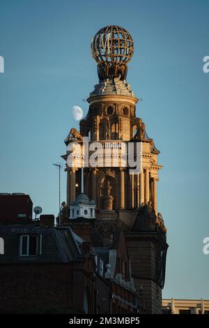 Un cliché vertical du London Coliseum contre le ciel bleu avec la lune en arrière-plan Banque D'Images