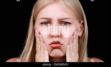 Deuxième menton, obésité. Portrait d'une femme de 30 ans tirant la peau sur son menton regarde dans l'appareil photo avec un aspect frustré. Problèmes de Banque D'Images