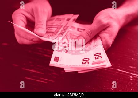 homme d'affaires comptant de l'argent. les mains de hommes riches tiennent et comptent des billets en espèces de 50 euros de billets ou de billets en monnaie. tons magenta viva, couleur tendance de Banque D'Images