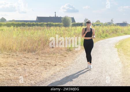 Jeune belle femme jogging dans le parc d'été. Banque D'Images