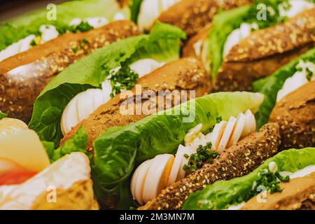 Variété de délicieux sandwiches avec salade et œufs dans la fenêtre d'un magasin ou d'un supermarché. En-cas et fastfood concept Banque D'Images