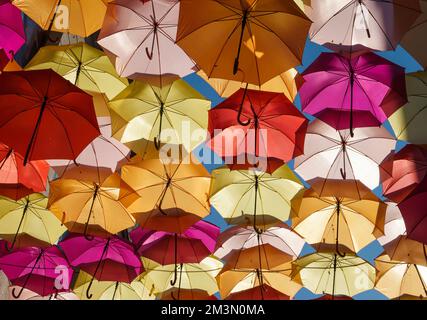 Parasols colorés rétroéclairés suspendus du ciel décorant une rue. Banque D'Images