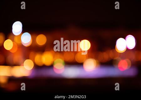 Fond rose doré brillant et flou de fête. Sur la vue de Noël de la ville noire, des lumières de bokeh jaunes éclairant hors de la mise au point. Vierge pour les cartes postales, place pour Banque D'Images