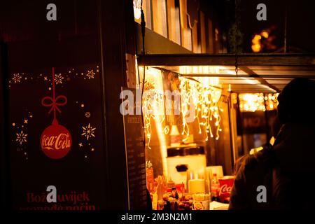 Zagreb, Croatie - 8 décembre 2022: Fête de Noël de Coca Cola à Zagreb. Nourriture de charité, salon des boissons. Maison de marché en bois décorée de guirlandes. W Banque D'Images