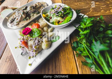 Boulettes de pommes de terre aux filets de sauce aux champignons. Persil à côté de l'assiette blanche. Plat de restaurant. Photo de haute qualité Banque D'Images