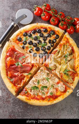 Pizza italienne four seasons ou quattro stagioni inclure une combinaison de tomates, mozzarella, champignons, artichauts, jambon, et les olives sur le tabl Banque D'Images
