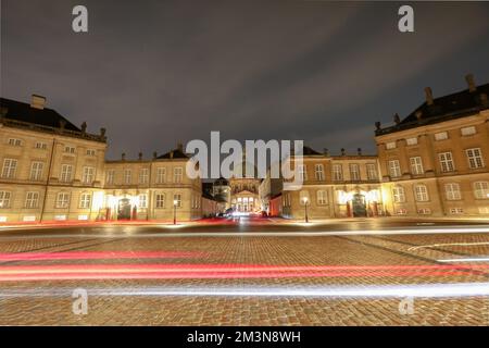 Une longue exposition de sentiers lumineux sur la route pavée de la place Amalienborg, Copenhague, Danemark Banque D'Images