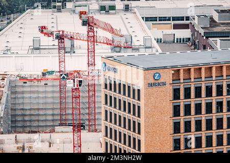 28 juillet 2022, Cologne, Allemagne : grues de construction sur le chantier et logo Zurich Insurance Group sur un centre d'affaires Banque D'Images