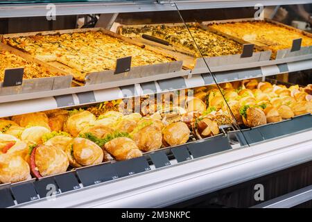 Variété de délicieux sandwiches avec diverses garnitures dans la fenêtre d'un magasin ou d'un supermarché. En-cas et restauration rapide Banque D'Images