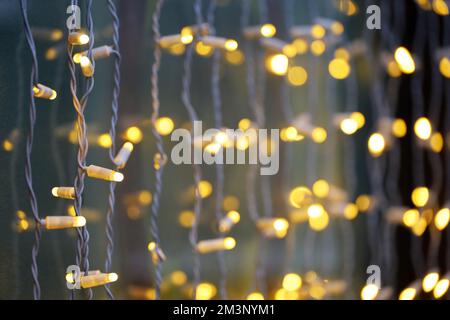 Lumières de fête sur les guirlandes électriques. Décorations de Noël, éclairage du nouvel an dans la fenêtre sur la rue de la ville Banque D'Images