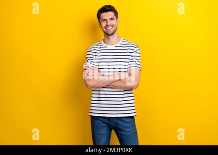 Photo positive jeune homme beau beaming sourire bras pliés isolés sur fond jaune Banque D'Images