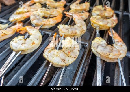 Un gros plan de crevettes sur brochettes cuisant sur un gril Banque D'Images