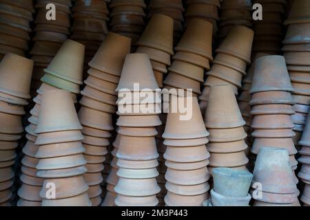 Gros plan des piles de pots de fleurs de terre cuite anciens et altérés dans le hangar de jardinage Banque D'Images