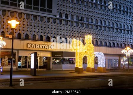 Magdebourg, Allemagne - 11 décembre 2022: Rue de Magdebourg décorée avec Otto King cavalier figure cheval lumière LED lampe centre ville contre Galeria Banque D'Images