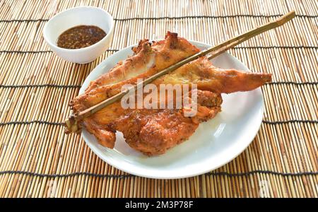 bâton de bois de poulet rôti sur plaque trempée avec sauce épicée Banque D'Images