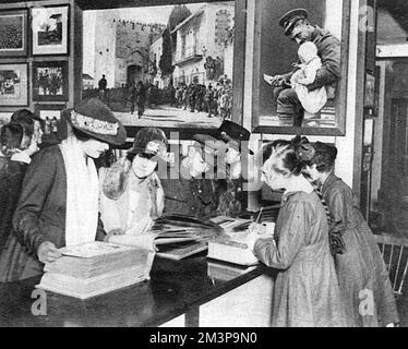 Clients inspectant des albums photo dans un nouveau bureau pour la vente de photographies officielles de guerre ouvertes par le Ministère de l'information à Coventry Street par John Buchan en octobre 1918. Date: 1918 Banque D'Images