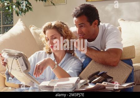 Jeune couple assis sur un canapé en choisissant des motifs pour le mobilier Banque D'Images
