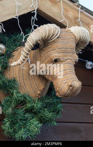 Décoration de Noël bourrée de vache bovine suspendue sur un mur en bois pendant la saison festive célébrant la nativité de Jésus Christ, stoc Banque D'Images