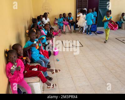 MBOUR, SÉNÉGAL - JANVIER CIRCA, 2021. Petits enfants noirs mignons non identifiés les enfants avec des uniformes sont assis sur un banc dans leur école primaire. Vin Banque D'Images