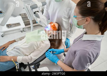 Dentiste effectuant la procédure dentaire sur le client Banque D'Images