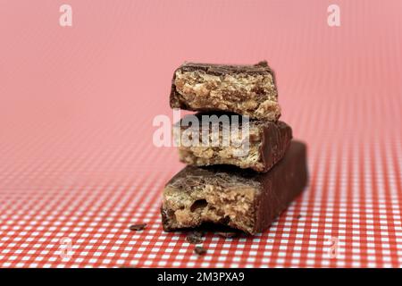 Barre de protéines d'énergie glacée au chocolat haché sur fond rose Banque D'Images