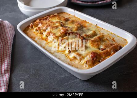 Cocotte de pâtes fraîches avec cannelloni farcis. Cuit avec de la sauce bolognaise et du béchamel. Nappé de mozzarella. La vie réelle Banque D'Images
