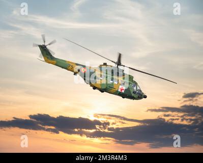 Hélicoptère IRA 330 militaire et utilitaire de la Force aérienne roumaine contre le ciel au coucher du soleil. Banque D'Images