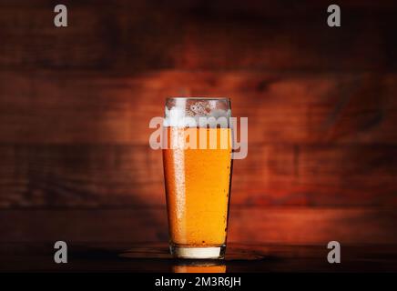 tasse à bière en verre avec bière sur fond de bois Banque D'Images