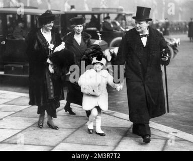 M. et Mme Winston Churchill et leur petite fille au passé de mars des gardes au Palais de Buckingham. La date de la photographie est marquée au dos comme 1910, mais doit en fait être autour de 1915 ou 1916 comme Diana, la première fille des Churchill est née en 1909. Date: c.1915 Banque D'Images