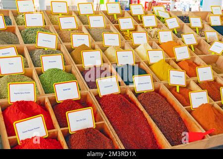 Diverses épices à base de plantes et assaisonnements dans des boîtes carrées portant des noms sur le comptoir du marché Banque D'Images