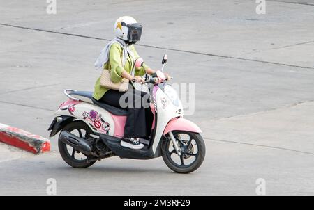 SAMUT PRAKAN, THAÏLANDE, FÉVRIER 23 2022, Une femme avec casque fait une moto Banque D'Images