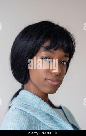 Jeune femme afro-américaine noire avec un poil droit regardant l'appareil photo - Portrait vertical Banque D'Images