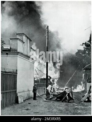 Les civils polonais face à un incendie causé par une bombe incendiaire en Pologne. La sphère contextualise l'homme de gauche, le décrivant comme un boucher dont la fille avait été blessée lors d'une attaque aérienne. Date : septembre 1939 Banque D'Images