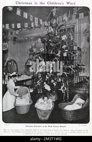 Les nourrissons du quartier de Goldsmith, à l'hôpital du Nord-est, sur Hackney Road, à Londres. Montrant un énorme arbre de Noël dans le quartier, décoré avec des craquelins, des poupées, des perles et un surmatelas d'ange. Date: 1905 Banque D'Images