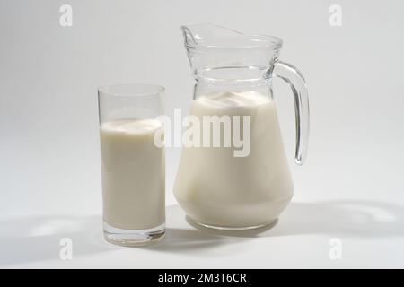 Verre et pot de lait frais sur fond gris. Produit laitier Banque D'Images