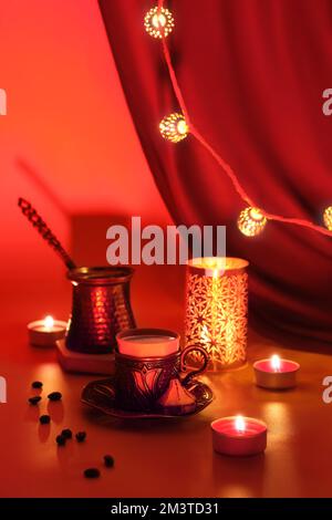 Cafetière turque et tasse traditionnelle avec bonbons orientaux. Lanterne en métal, guirlande ornée et lampes à thé. Viva magenta, couleur de l'année 2023. Rouge Banque D'Images