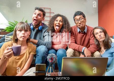 Grimacing generationz personnes, heureux jeunes blogueurs intelligents filmant de nouvelles vidéos vlog avec smartphone et ordinateur portable à la maison, les jeunes ayant le plaisir et la broa Banque D'Images