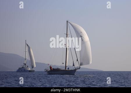 Bodrum, Turquie. 04 décembre 2022 : les voiliers naviguent par temps venteux dans les eaux bleues de la mer Égée, sur les rives de la célèbre destination de vacances Banque D'Images