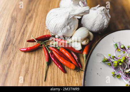 Tête entière d'ail et petits piments rouges. Concept de cuisine de restaurant. Gros plan. Intérieur. Photo de haute qualité Banque D'Images