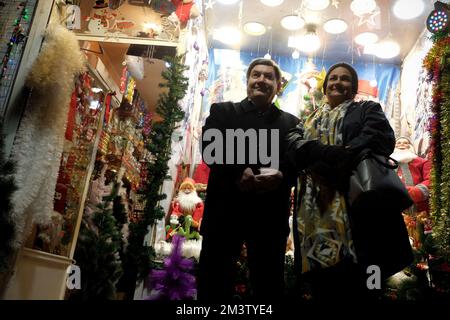 Téhéran, Téhéran, Iran. 16th décembre 2022. Un couple iranien pose devant un magasin vendant des décorations de Noël sur le marché traditionnel de Noël où la plupart des Arméniens vivent à Téhéran, en Iran, sur 16 décembre 2022. Des cadeaux colorés, des arbres de Noël et des ornements sont présentés pour les personnes qui veulent acheter des ornements de Noël traditionnels. (Credit image: © Rouzbeh Fouladi via ZUMA Press Wire) Banque D'Images