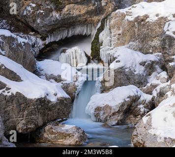 les petites cascades entre les pierres d'un ruisseau avec neige et glace en hiver Banque D'Images