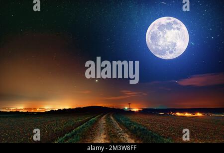 Pleine lune sur route de terre Banque D'Images