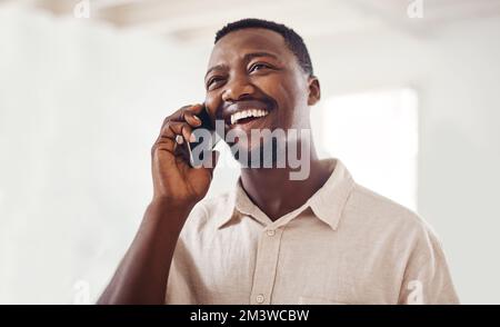 C'est une excellente nouvelle. un jeune homme d'affaires parlant sur un téléphone portable dans un bureau. Banque D'Images