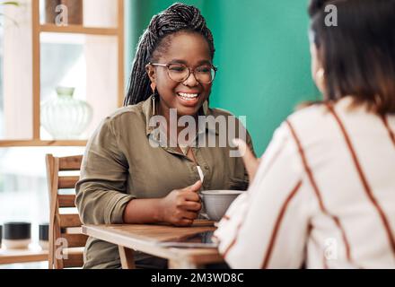 Où la conversation est un grand comme le café. deux jeunes femmes discutant dans un café. Banque D'Images